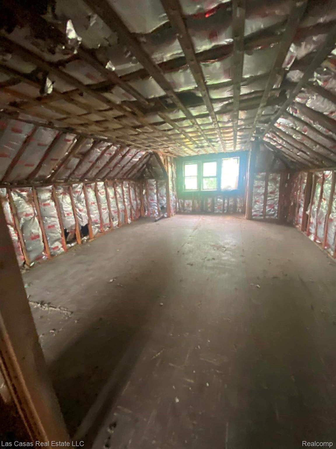 7545 Holmes Street Detroit, MI 48210 - Photo 9 of 12 Spacious attic space featuring exposed wood framing, wall and ceiling insulation, and multiple windows