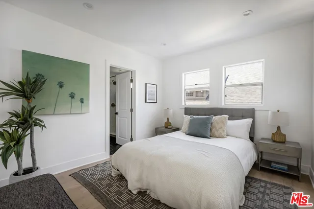 a bedroom with a bed and a potted plant