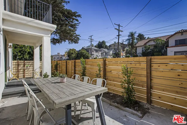 a view of a patio with table and chairs a barbeque with wooden floor and fence