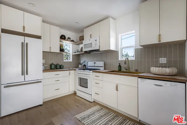 a kitchen with granite countertop white cabinets and white appliances
