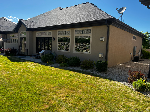 1154 Sunset Dunes Way Draper, UT 84020 - Photo 2 of 50 Stucco exterior featuring dark trim, multiple large windows with decorative transoms, and a concrete patio