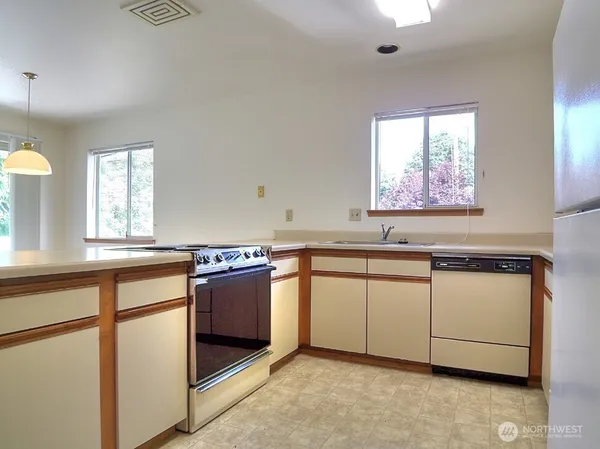 a kitchen with stainless steel appliances granite countertop a sink and a stove top oven