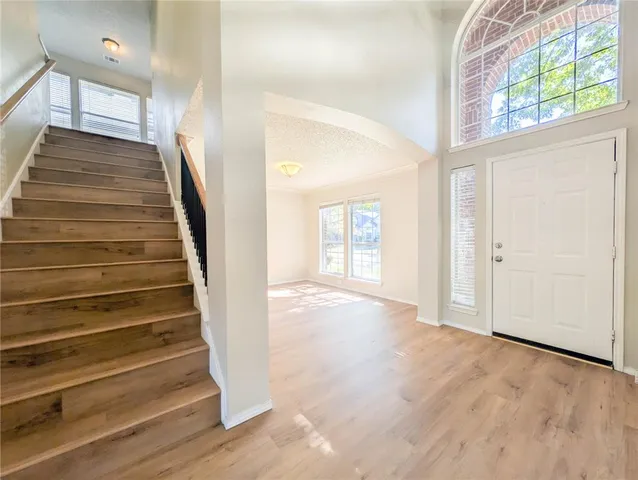 a view of a hallway with wooden floor and entryway
