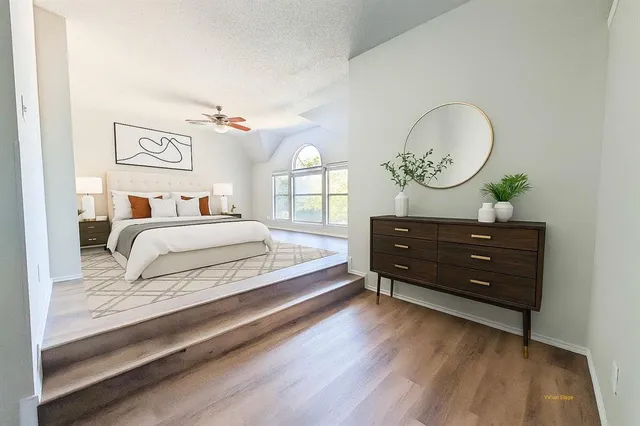 a view of empty room with wooden floor and ceiling fan