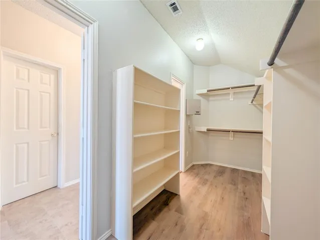 a view of walk in closet with empty racks