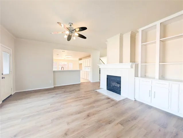 a view of a hallway with wooden floor and a bathroom