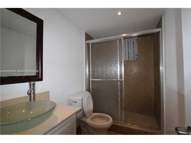 525 West 69th Street, Unit 209 Hialeah, FL 33014 - Photo 3 of 3 a bathroom with a toilet sink and mirror