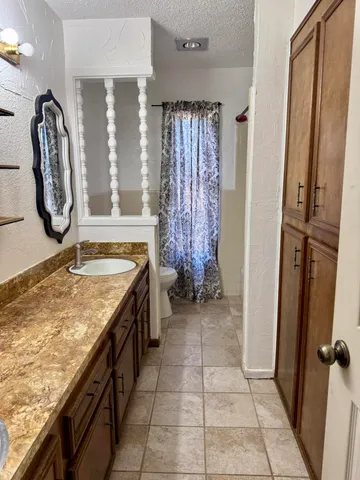 a bathroom with a granite countertop sink and a mirror