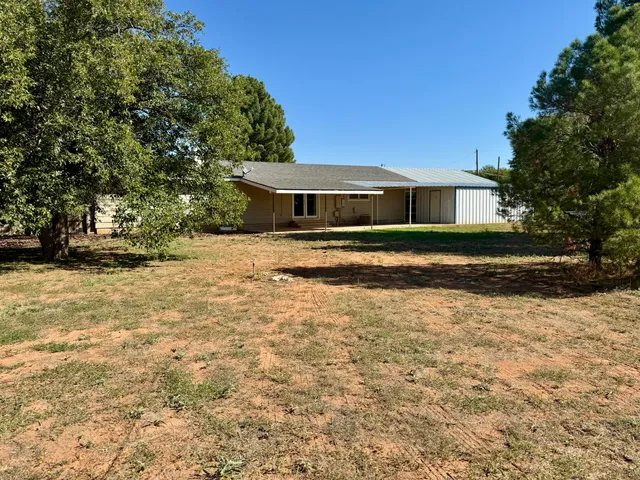 a front view of a house with yard and trees