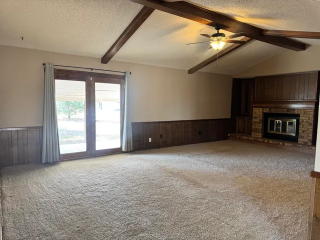 a view of an empty room with a fireplace and a window