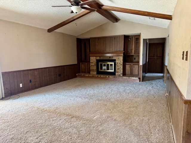 a view of an empty room with a fireplace and a window