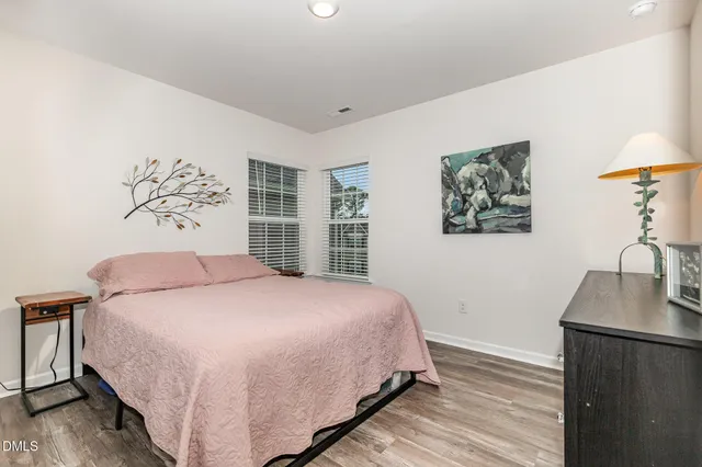 a bedroom with a bed chandelier and a window