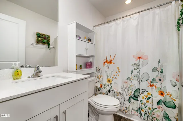 a bathroom with a sink toilet vanity and shower