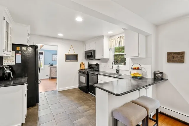 a kitchen with stainless steel appliances a refrigerator sink stove microwave and cabinets