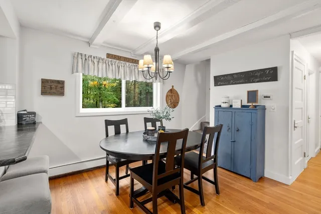 a dining room with furniture a chandelier and wooden floor