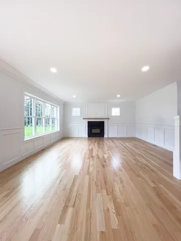 a view of empty room with wooden floor and fireplace