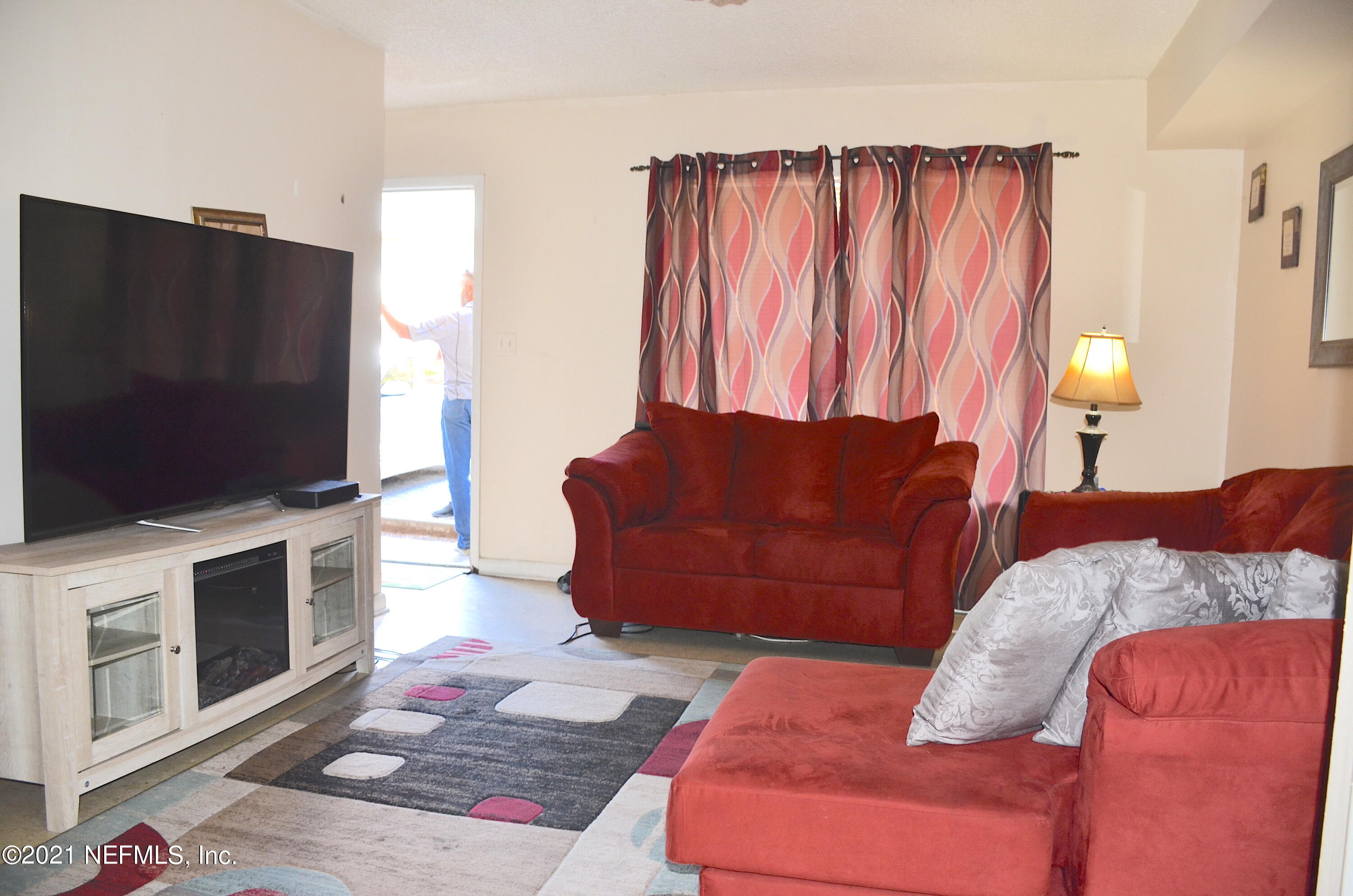681 Rainer Road, Unit 3 Baldwin, FL 32234 - Photo 23 of 28 a living room with furniture a flat screen tv and a fireplace