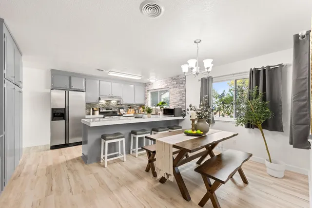 a kitchen with a dining table chairs stainless steel appliances and cabinets