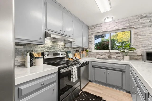 a kitchen with stainless steel appliances granite countertop a sink stove and refrigerator