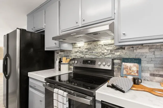 a kitchen with granite countertop a stove and a refrigerator