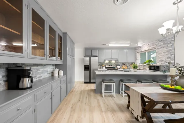 a kitchen with a table chairs refrigerator and cabinets