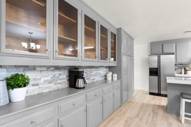 a kitchen with stainless steel appliances white cabinets and wooden floor