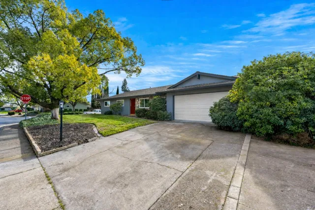 a view of a house with a yard and potted plants