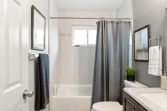 a en suite spacious bedroom with a bed and a flat screen tv