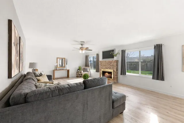 a living room with furniture a fireplace and a large window