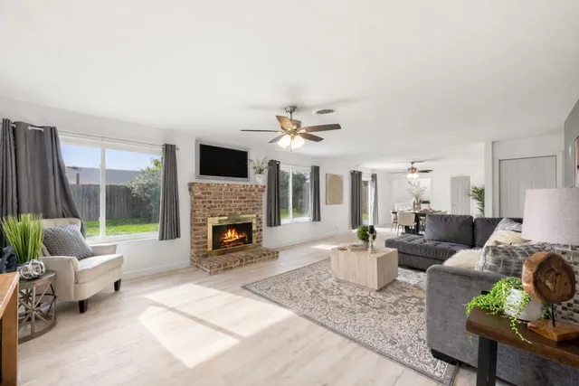 a living room with furniture fireplace and a large window