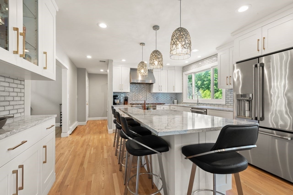 9 Bragg Road Foxboro, MA 02035 - Photo 12 of 42 a large kitchen with granite countertop a stove a sink dishwasher a dining table and chairs with wooden floor