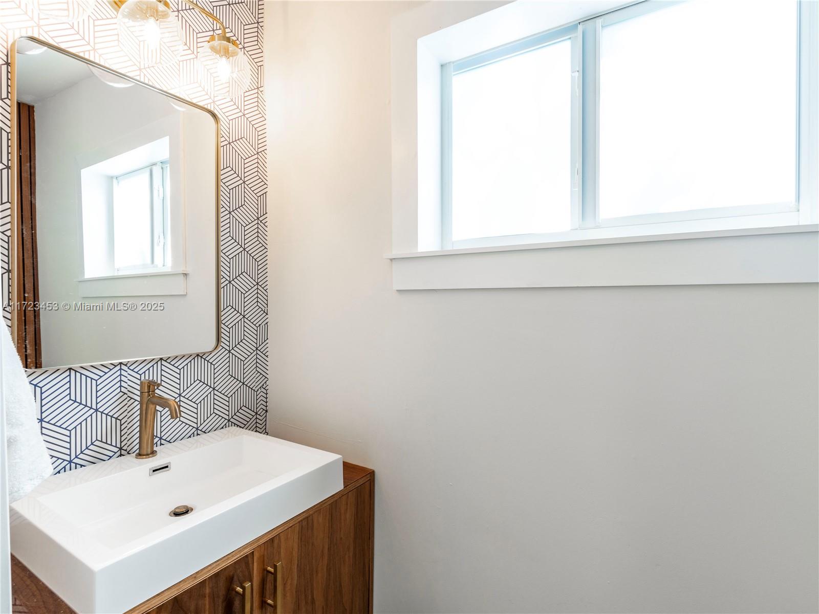 1001 Southwest 23rd Road Miami, FL 33129 - Photo 29 of 38 a bathroom with a sink a mirror and a window