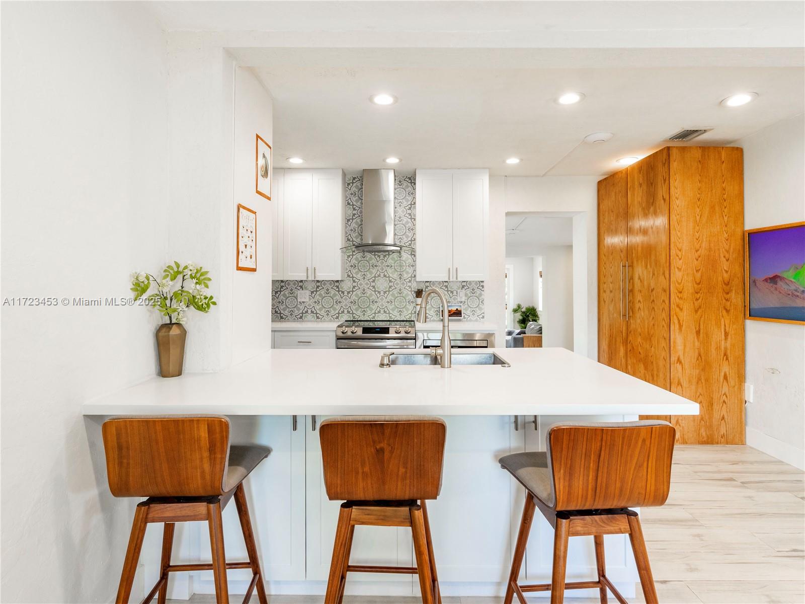 1001 Southwest 23rd Road Miami, FL 33129 - Photo 6 of 38 a kitchen with stainless steel appliances kitchen island granite countertop wooden cabinets and table