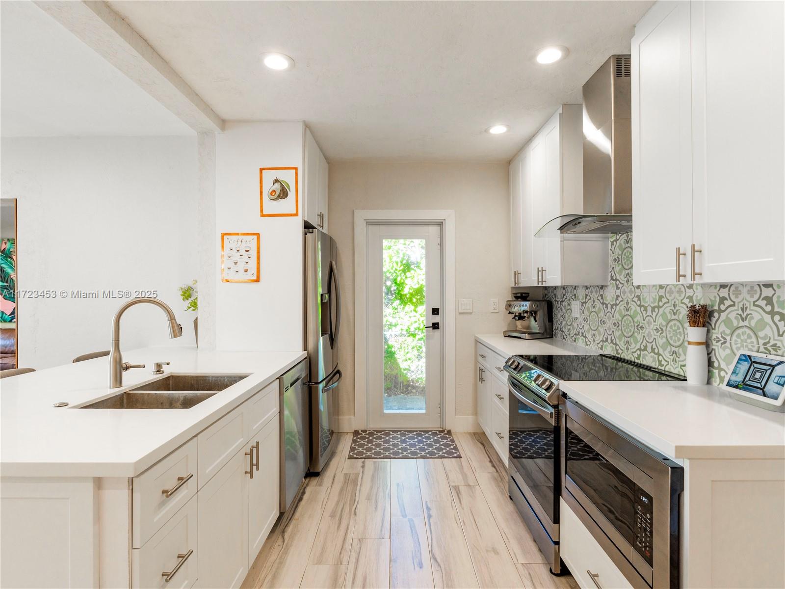 1001 Southwest 23rd Road Miami, FL 33129 - Photo 8 of 38 a kitchen with stainless steel appliances granite countertop a sink stove and refrigerator
