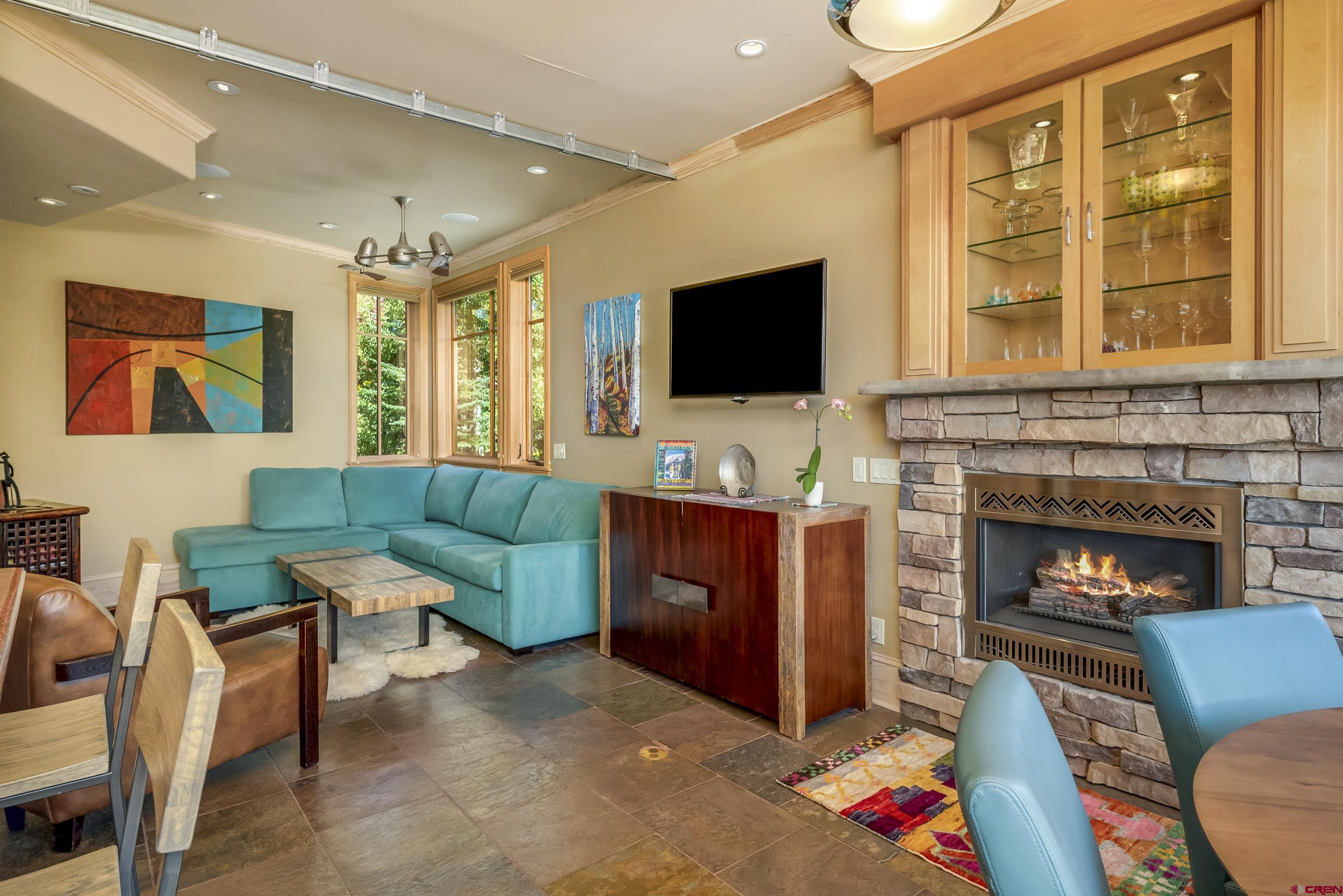 19 Castle Road, Unit 5 Crested Butte, CO 81225 - Photo 11 of 32 a living room with furniture a fireplace and a flat screen tv