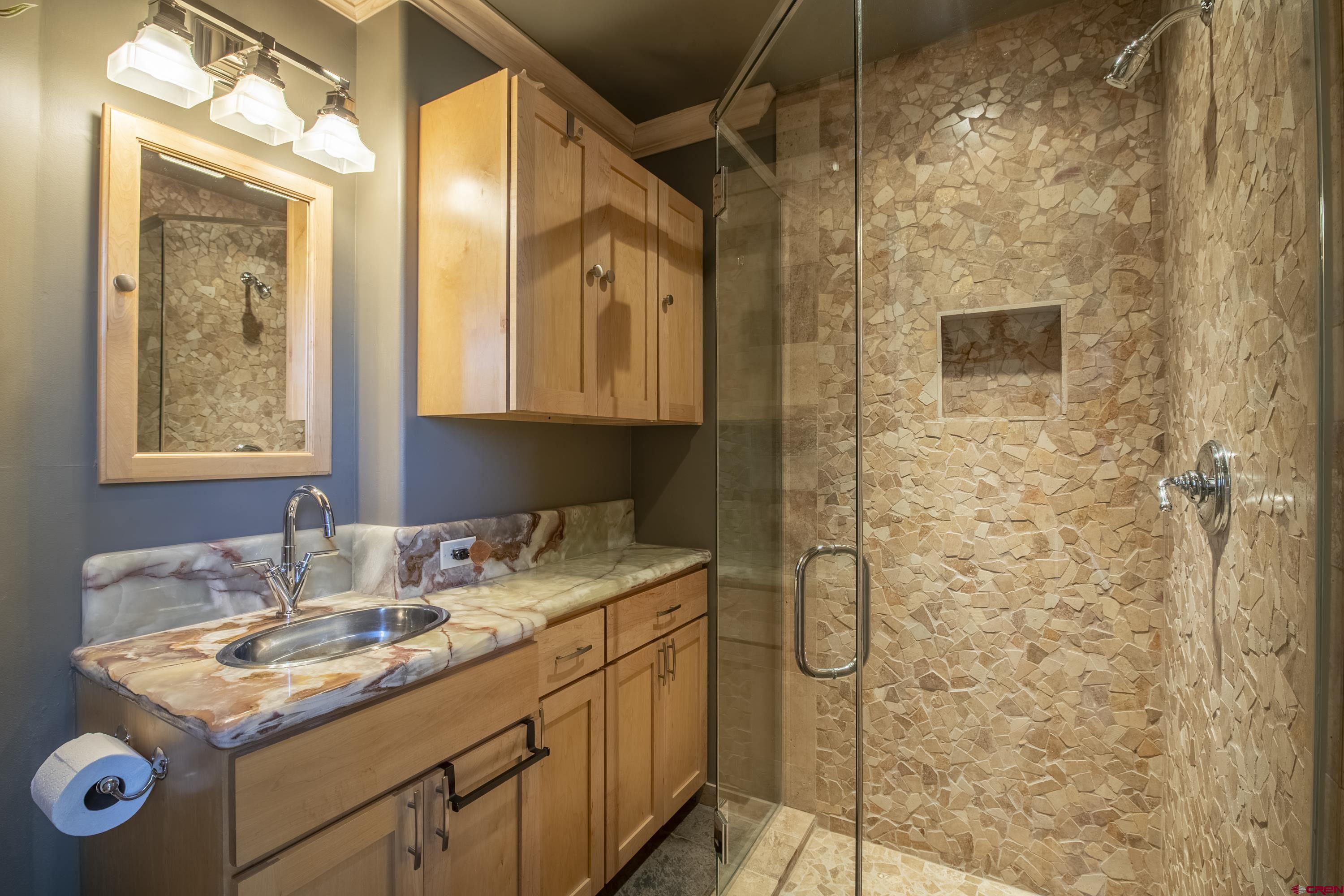 19 Castle Road, Unit 5 Crested Butte, CO 81225 - Photo 13 of 32 a bathroom with a shower sink and mirror