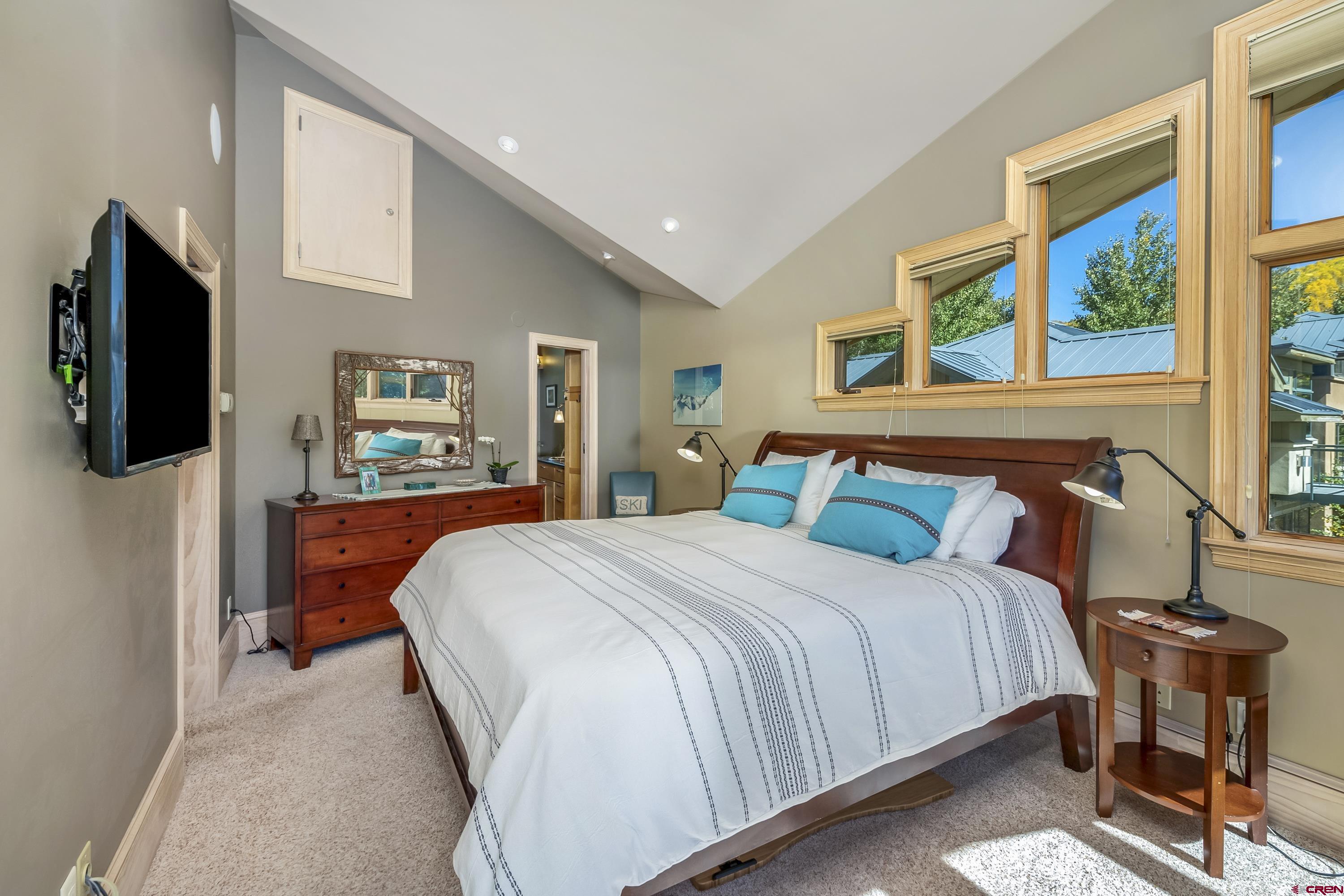 19 Castle Road, Unit 5 Crested Butte, CO 81225 - Photo 19 of 32 a bedroom with a bed and a flat tv screen on the dresser
