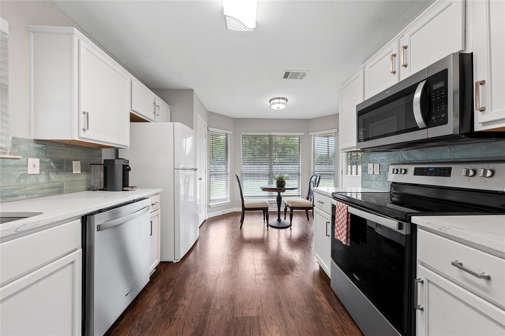 10124 Bunting Drive Waco, TX 76708 - Photo 5 of 18 a kitchen with stainless steel appliances a stove a sink cabinets and a refrigerator