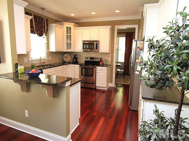 2208 Karns Place Raleigh, NC 27614 - Photo 9 of 25 a kitchen with stainless steel appliances granite countertop a refrigerator a sink dishwasher a stove and a dining table with wooden floor