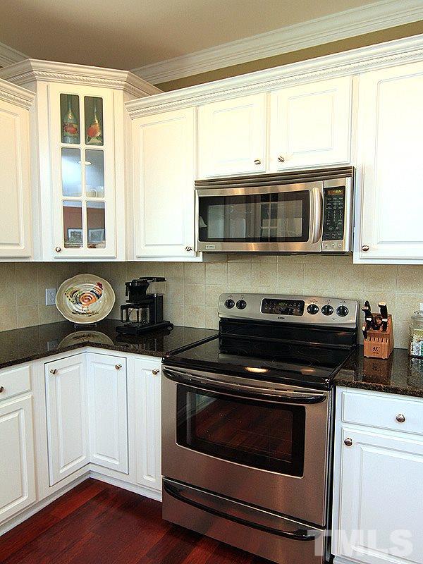 2208 Karns Place Raleigh, NC 27614 - Photo 10 of 25 a kitchen with stainless steel appliances a stove a microwave and cabinets