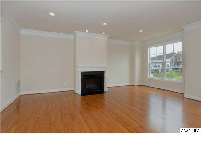 2076 Avinity Loop Charlottesville, VA 22902 - Photo 5 of 26 a open hall with a fireplace and wooden floor