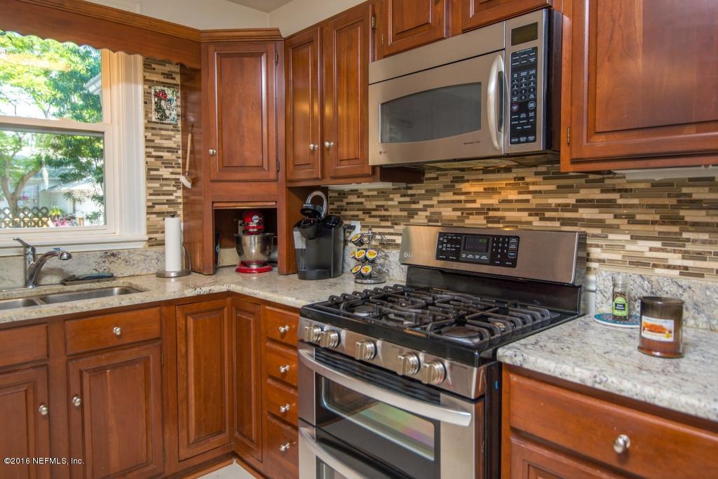 1128 Greenridge Road Jacksonville, FL 32207 - Photo 17 of 37 a kitchen with stainless steel appliances granite countertop a stove a sink and a microwave