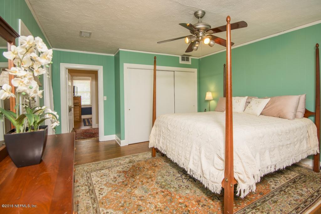 1128 Greenridge Road Jacksonville, FL 32207 - Photo 20 of 37 a bedroom with a bed and a chandelier