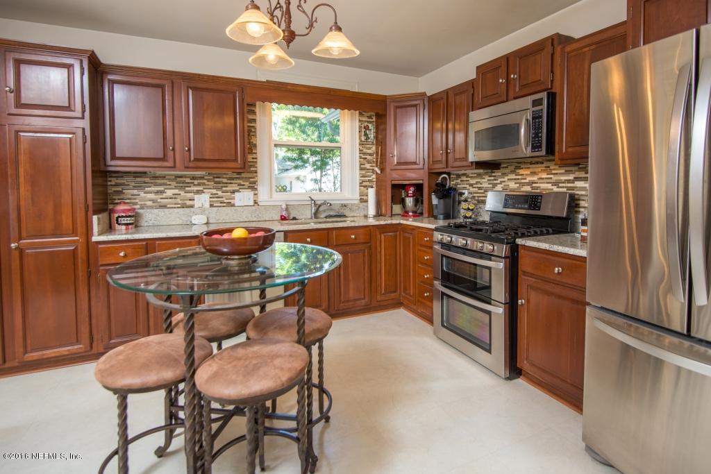 1128 Greenridge Road Jacksonville, FL 32207 - Photo 3 of 37 a kitchen with stainless steel appliances granite countertop a stove a sink a microwave a refrigerator cabinets and dining table