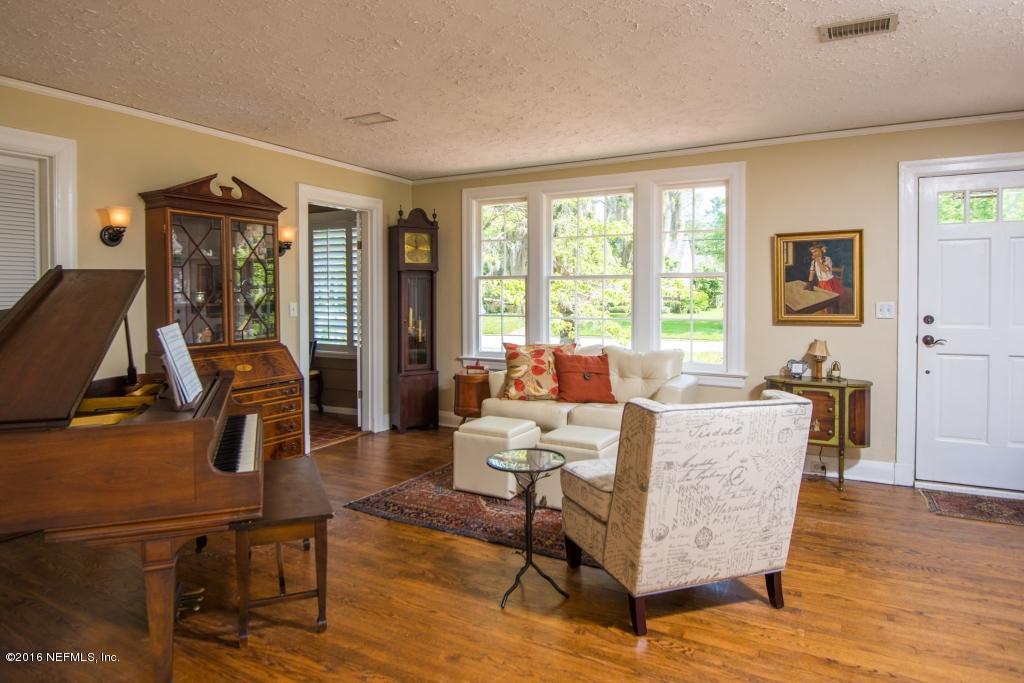 1128 Greenridge Road Jacksonville, FL 32207 - Photo 6 of 37 a living room with furniture a flat screen tv and a floor to ceiling window