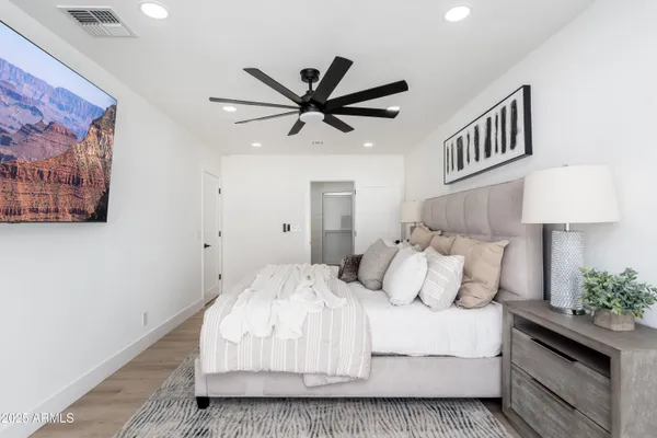 a bedroom with a large bed and a chandelier