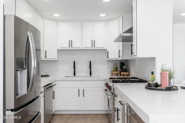 a kitchen with stainless steel appliances a stove refrigerator sink and cabinets