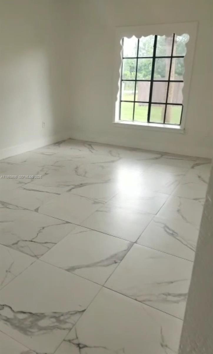 13949 Southwest 281st Terrace, Unit 13949 Homestead, FL 33033 - Photo 3 of 11 an empty room with a empty space and windows