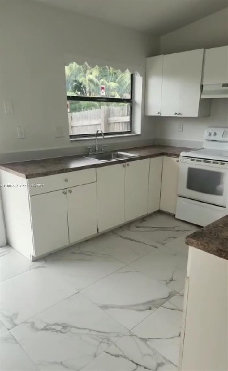 13949 Southwest 281st Terrace, Unit 13949 Homestead, FL 33033 - Photo 8 of 11 a kitchen with granite countertop white cabinets and white appliances