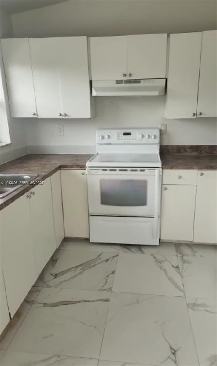 13949 Southwest 281st Terrace, Unit 13949 Homestead, FL 33033 - Photo 9 of 11 a kitchen with white cabinets and appliances